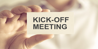 Businessman holding KICK-OFF MEETING message card