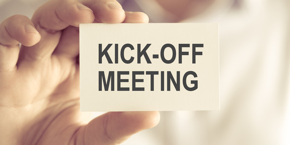 Businessman holding KICK-OFF MEETING message card