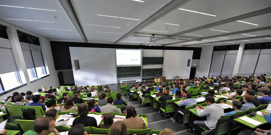 Students sit in a lecture hall in the seminar building at the Campus North.