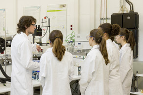 Four students and a professor in a laboratory.